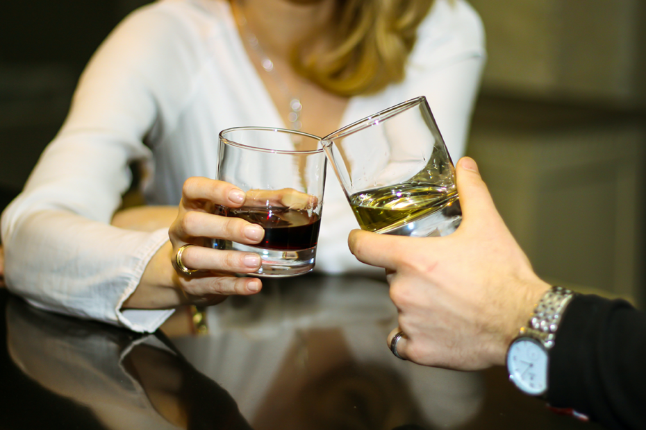 two hands holding alcohol drinks