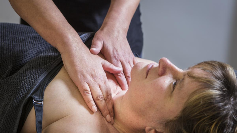 hands on a women neck as she receives MLD treatment